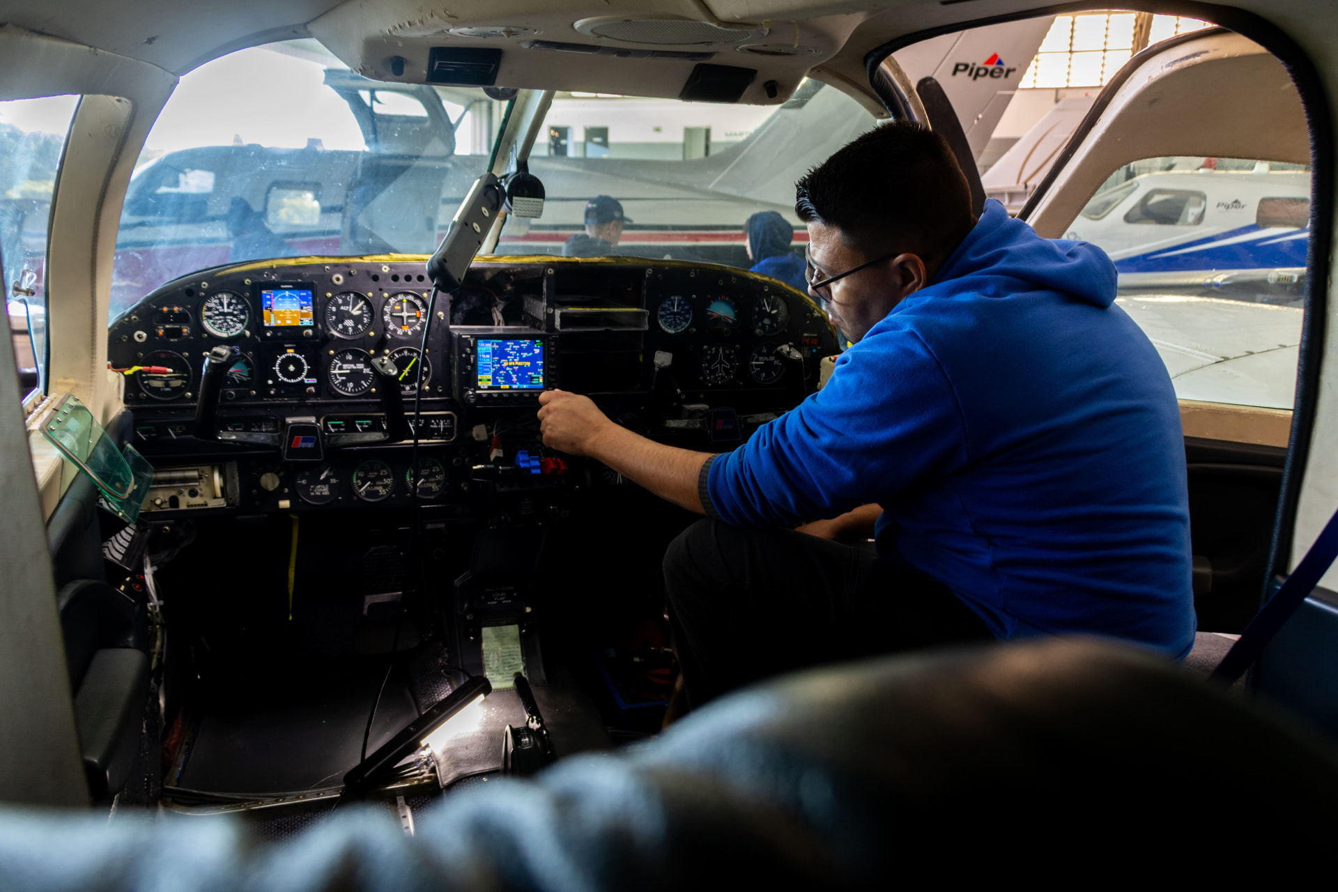 Técnico da Marte Updates instalando aviônicos no painel da aeronave